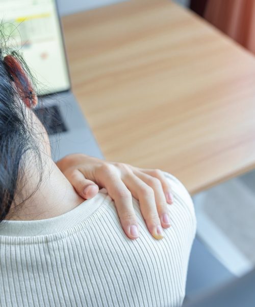Woman having Neck and Shoulder pain during work long time on workplace. due to fibromyalgia, rheumatism, Scapular pain, office syndrome and ergonomic concept
